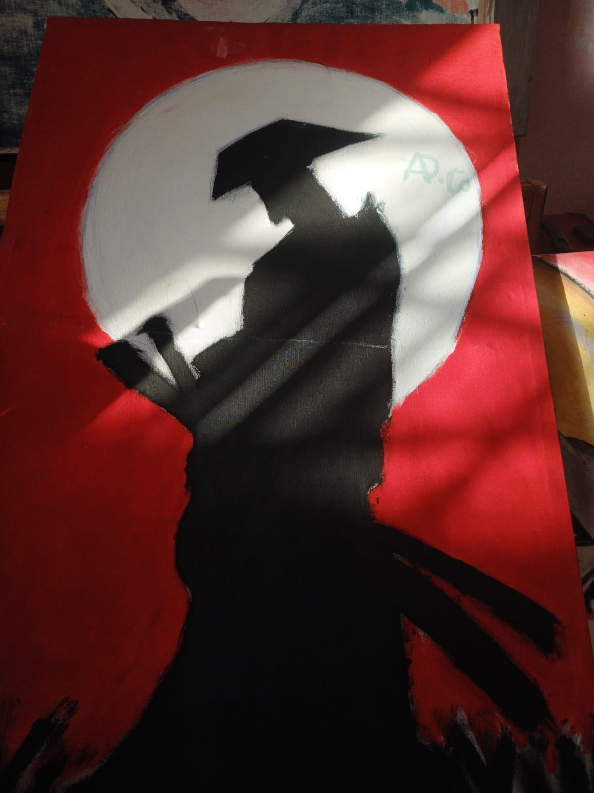 Silhouette painting of a figure with an umbrella crossing a white moon on a red background